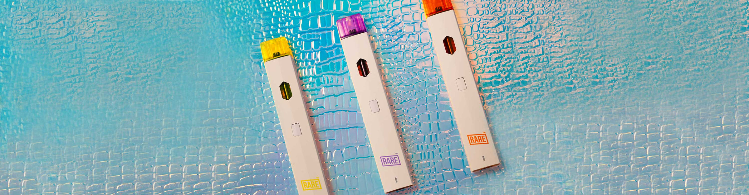 Rare CBD vaporizers laying down on colorful textured background