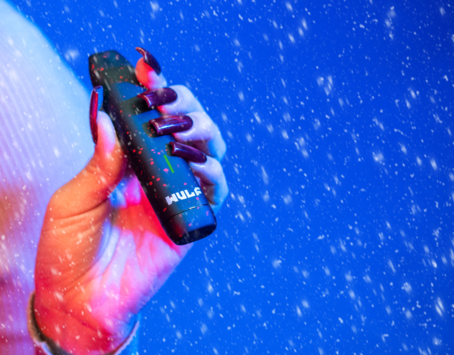 Woman holding Wulf LX slim in front of blue studio background with snow falling